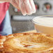 A person sprinkling Florida Crystals Organic Raw Cane Sugar on a pastry.