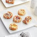 A white plate with a selection of White Toque mini danishes on it.