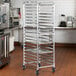 A Regency metal sheet pan rack with pans on it.