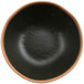 A black melamine bowl with a brown clay trim.