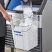 A woman pouring ice into a container using a Vigor ice tote.