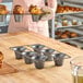 A non-stick carbon steel popover pan with six cups, designed for baking popovers.