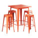 An orange metal Lancaster Table & Seating bar table with four barstools.