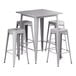 A Lancaster Table & Seating nickel gray metal bar height table with four stools.