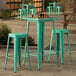 A Lancaster Table & Seating aquamarine outdoor table with two green barstools.