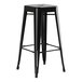 A Lancaster Table & Seating black metal bar height table with 2 black metal backless barstools.