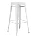 A white metal Lancaster Table & Seating barstool with a metal base and legs with a white seat.