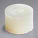 A white plastic spacer with a white circle on the bottom.
