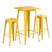 A Lancaster Table & Seating citrine yellow metal bar table with 2 yellow barstools.