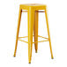 A Lancaster Table & Seating citrine yellow metal barstool with legs.