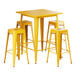 A Lancaster Table & Seating citrine yellow table with four barstools.