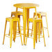 A Lancaster Table & Seating citrine yellow metal table with four backless barstools.