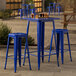 A Lancaster Table & Seating blue metal bar height table with blue quartz top and 2 blue barstools.