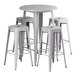 A white table with a silver edge and four white stools with legs.