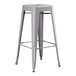 A gray metal Lancaster Table & Seating barstool with a black seat.