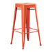 An orange metal barstool with a wooden seat.