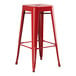 A Lancaster Table & Seating red metal backless barstool with legs and a seat.