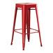 A red metal Lancaster Table & Seating backless barstool with legs.