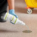 A person in blue gloves pouring Noble Eco EDM+ Ultra Enzymatic Drain Maintainer from a white bottle into a drain.