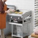 A chef using a Cooking Performance Group countertop electric griddle to cook food.