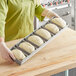 A woman placing dough into a Baker's Mark bread loaf pan.