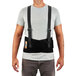 A man wearing a ProFlex Ergodyne back support brace with suspenders.