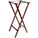 A Lancaster Table & Seating mahogany wood folding tray stand with two legs.