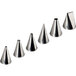 A row of six shiny metal Gobel icing tips of different sizes.