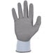 A close-up of a small gray Ergodyne ProFlex warehouse glove with a white and blue polyurethane palm coating.