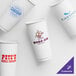 A group of customizable white paper hot cups with different logos.