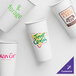 A customizable white 22 oz. paper cold cup with brown and green logos.