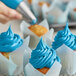 A close up of a Chefmaster Sky Blue frosted cupcake.