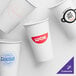 A group of customizable white paper cold cups with red logos.