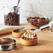 A silver pan with Ghirardelli milk chocolate wafers melting over a gas burner.