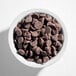 A white bowl filled with semi-sweet chocolate baking chips.