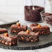 A group of Ghirardelli 100% Cacao chocolate brownies on a black plate.