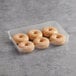 A plastic container of Rich's glazed yeast donut rings on a gray surface.