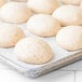 A tray of Rich's Whole Grain Dinner Roll Dough on a white surface.