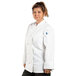 A woman wearing a white Uncommon Chef Sedona long sleeve chef coat.