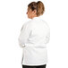 A woman wearing a white Uncommon Chef long sleeve chef coat.