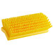 A Carlisle yellow floor scrub brush with bristles.