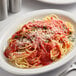 A plate of Furmano's Home Style Spaghetti Sauce with spaghetti and parmesan cheese on a table with a fork.