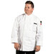 A man in a white Uncommon Chef long sleeve chef coat standing.
