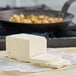 A large white block of Melt Organic salted butter on a table.