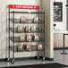 A mobile take-out cart with Regency black epoxy shelving and slanted drop-in baskets.