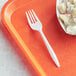 A white plastic fork on a plastic tray.