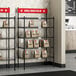 A Regency take-out shelving station with red signs on the shelves.