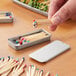 A person holding a silver tin of matches with colored heads.