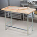 A rolling pin on an Advance Tabco wood top work table.