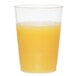 A WNA Comet Classicware clear plastic fluted tumbler filled with orange juice on a white background.